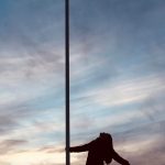 young person dancing around a flag pole